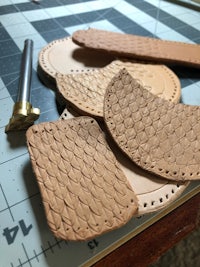 a group of leather pieces on a cutting board